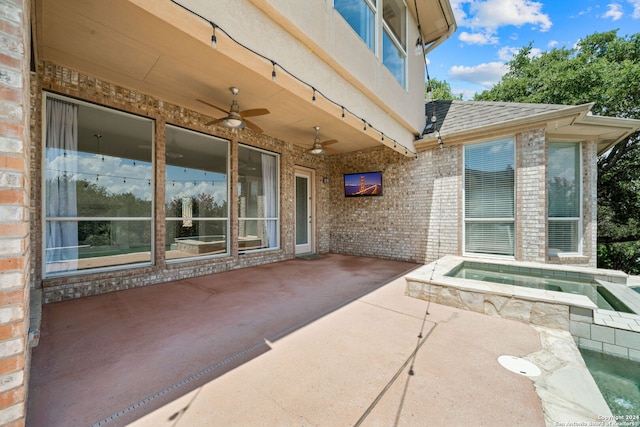 view of patio / terrace featuring an in ground hot tub and ceiling fan