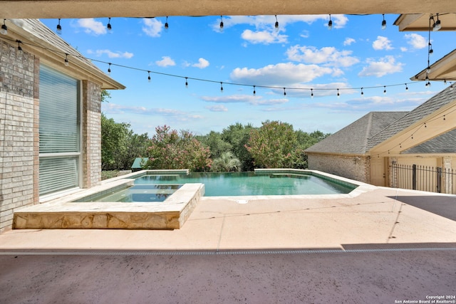 view of swimming pool featuring a patio area and an in ground hot tub