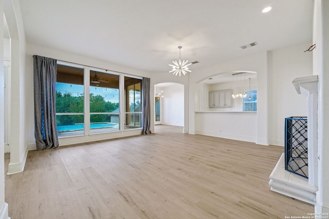 unfurnished living room featuring light hardwood / wood-style flooring and a chandelier