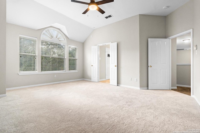 unfurnished bedroom with ceiling fan, lofted ceiling, and light carpet