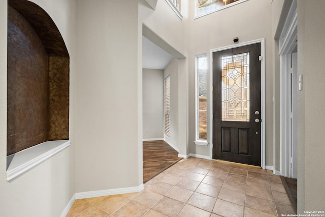 tiled entrance foyer with a towering ceiling