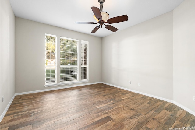 empty room with ceiling fan and dark hardwood / wood-style flooring