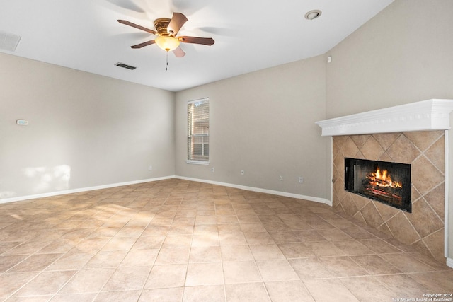 unfurnished living room with a tile fireplace, light tile patterned flooring, and ceiling fan