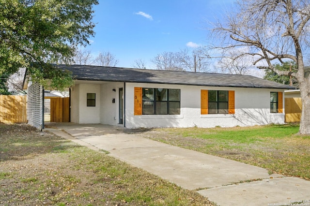 ranch-style house featuring a carport and a front lawn