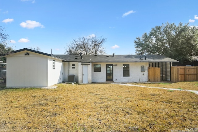 rear view of property featuring cooling unit and a lawn