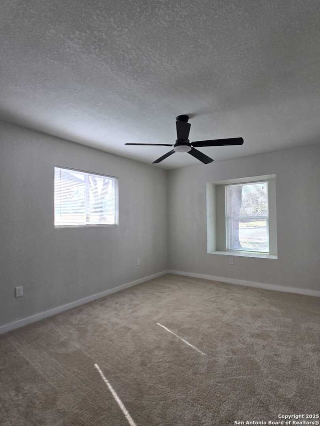 empty room with ceiling fan, carpet, and a textured ceiling