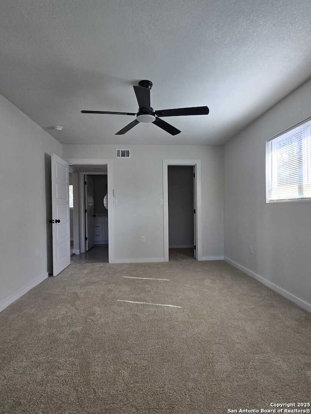 unfurnished bedroom with ceiling fan, carpet flooring, and a textured ceiling