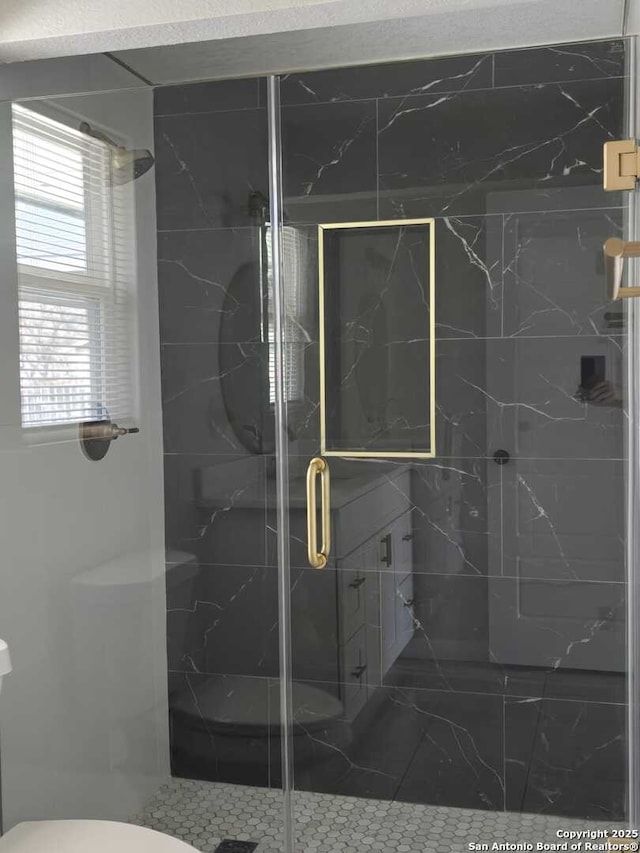 bathroom with toilet and a shower with shower door