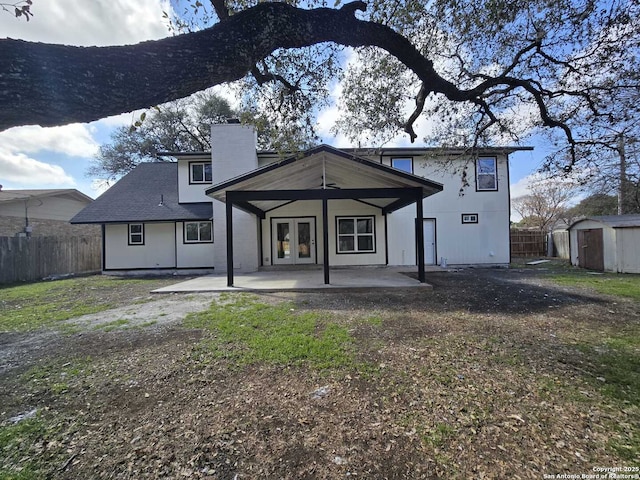 rear view of house with a patio area and a storage unit