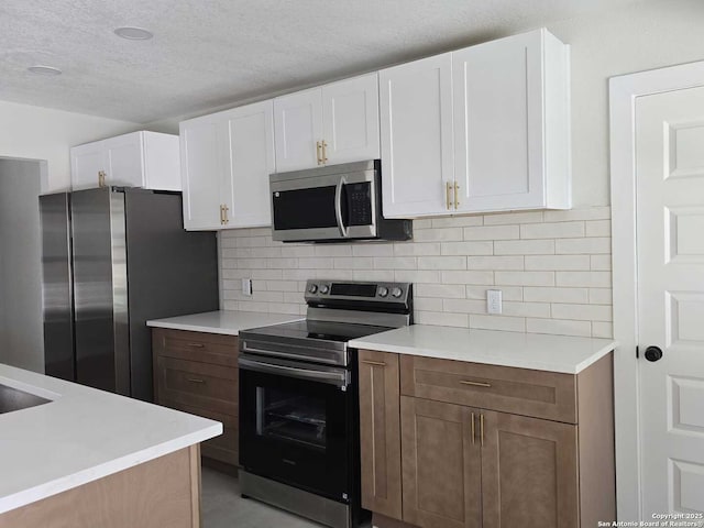 kitchen with stainless steel appliances, white cabinetry, tasteful backsplash, and a textured ceiling