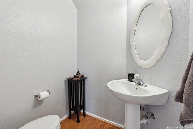 bathroom with toilet and hardwood / wood-style floors