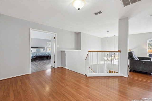 interior space featuring hardwood / wood-style flooring and an inviting chandelier