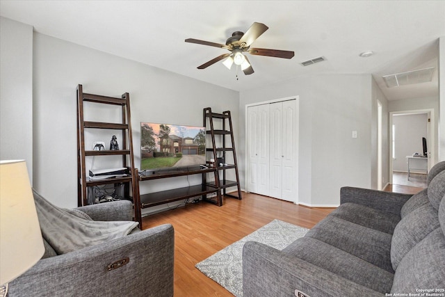 living room featuring hardwood / wood-style floors and ceiling fan