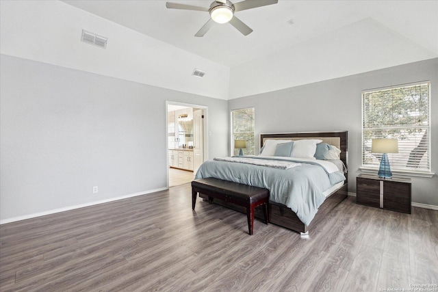 bedroom with multiple windows, connected bathroom, and wood-type flooring