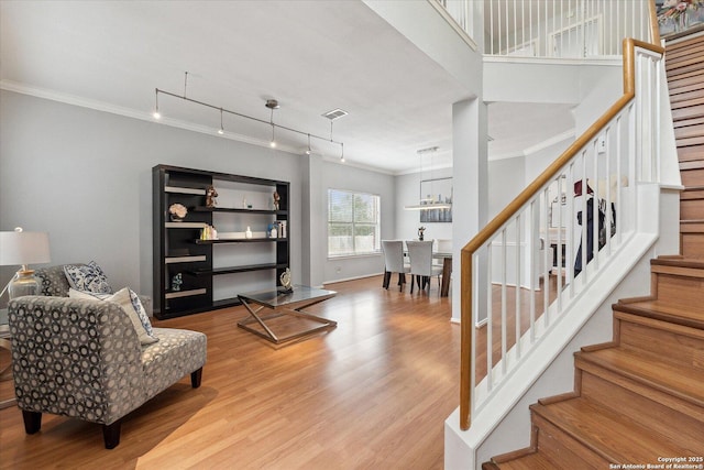 sitting room with ornamental molding, rail lighting, and light wood-type flooring