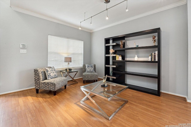 living area with crown molding, track lighting, and light wood-type flooring