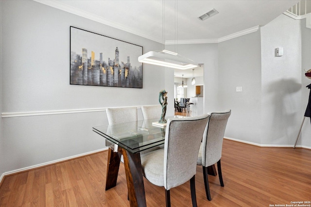 dining space featuring hardwood / wood-style flooring and ornamental molding