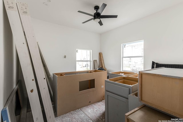 interior space with multiple windows and ceiling fan