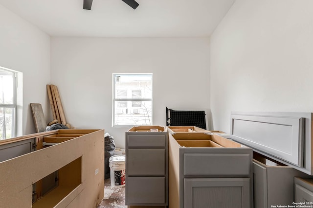 interior space with multiple windows and ceiling fan