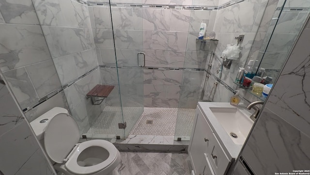 bathroom featuring an enclosed shower, vanity, tile walls, and toilet