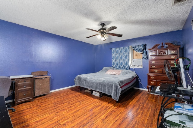 bedroom with ceiling fan, hardwood / wood-style floors, and a textured ceiling