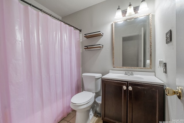 bathroom featuring tile patterned flooring, vanity, walk in shower, and toilet