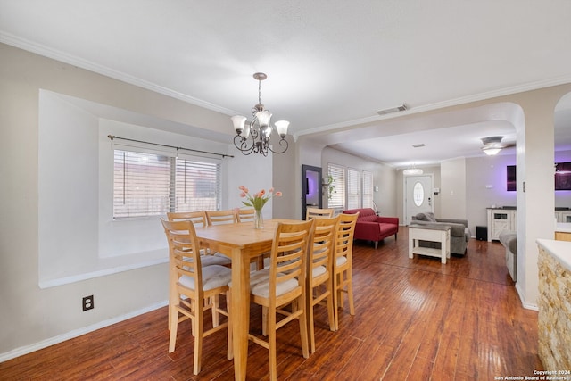 dining area featuring crown molding, dark hardwood / wood-style flooring, and a notable chandelier