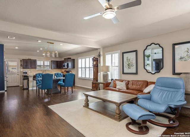 living room featuring dark wood-type flooring and ceiling fan