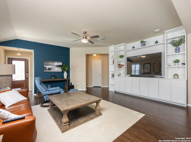 living room with ceiling fan, dark hardwood / wood-style floors, vaulted ceiling, and a fireplace