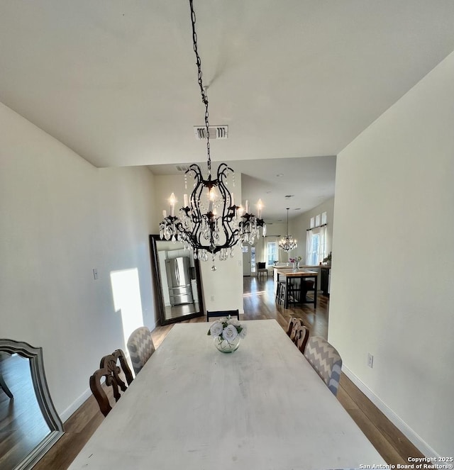 dining room featuring an inviting chandelier and dark hardwood / wood-style floors