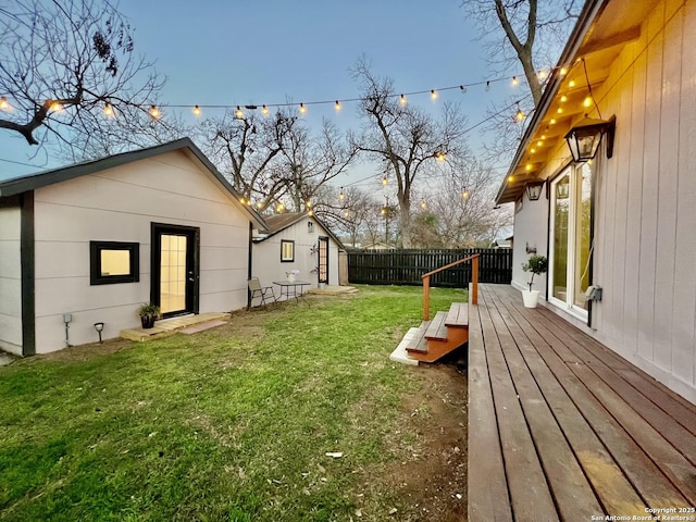 yard at dusk featuring an outbuilding and a deck