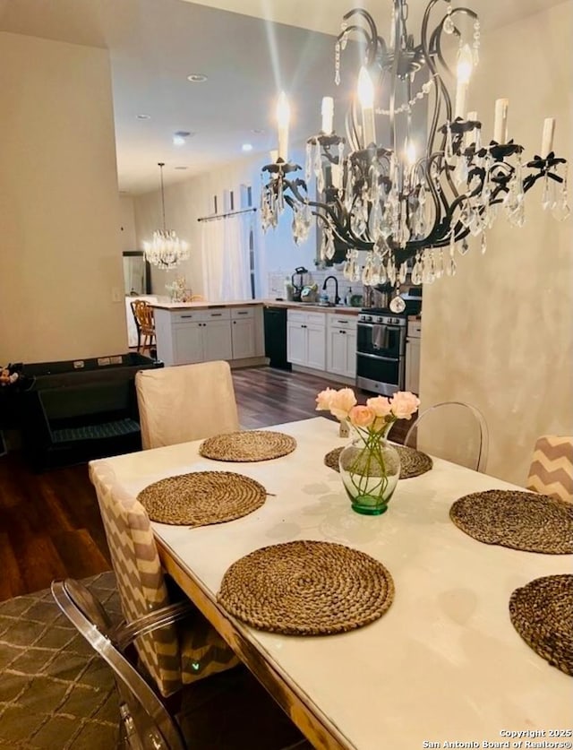 dining room with dark hardwood / wood-style flooring, a chandelier, and sink