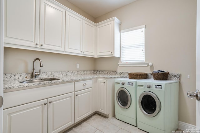 washroom with cabinets, sink, light tile patterned floors, and washer and clothes dryer