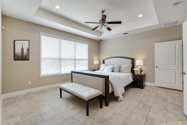 tiled bedroom featuring a raised ceiling and ceiling fan