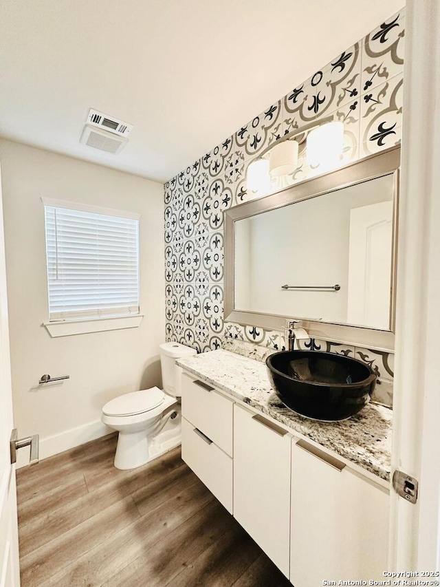 bathroom featuring vanity, hardwood / wood-style floors, and toilet