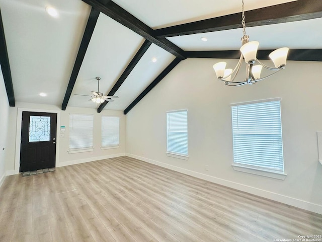unfurnished living room featuring ceiling fan with notable chandelier, lofted ceiling with beams, and light wood-type flooring