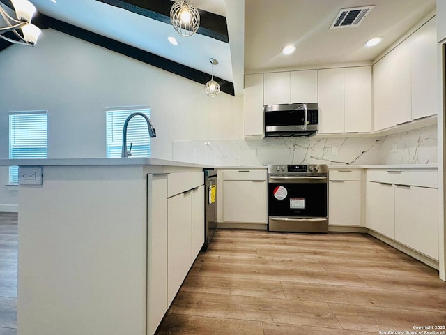 kitchen with appliances with stainless steel finishes, pendant lighting, vaulted ceiling with beams, white cabinets, and backsplash