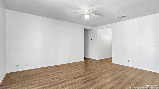 empty room featuring dark wood-type flooring and ceiling fan