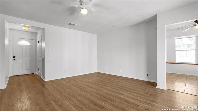 foyer entrance featuring hardwood / wood-style floors, a textured ceiling, and ceiling fan