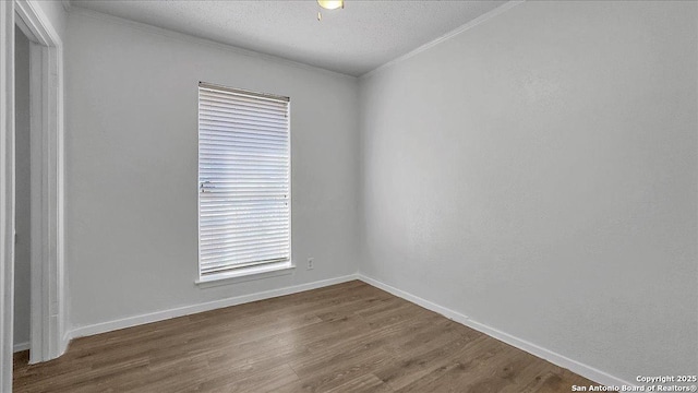 unfurnished room featuring hardwood / wood-style flooring, ornamental molding, and a textured ceiling