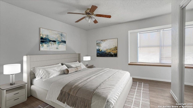 bedroom featuring wood-type flooring, ceiling fan, and a textured ceiling