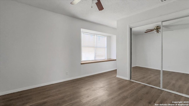 unfurnished bedroom featuring ceiling fan, a textured ceiling, dark hardwood / wood-style flooring, and a closet