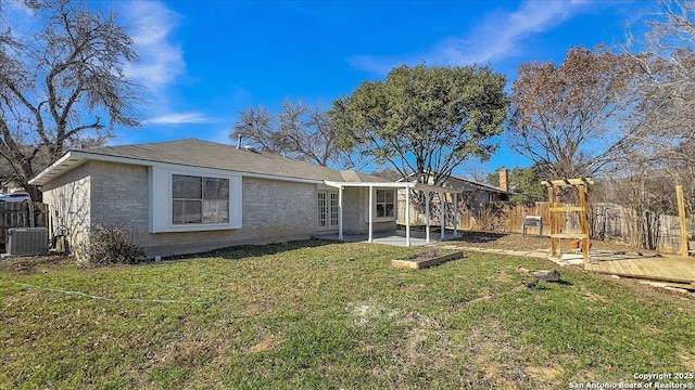 view of front of home with cooling unit and a front lawn