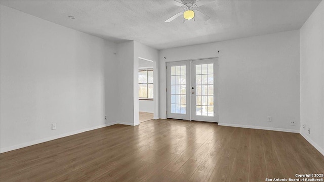 empty room featuring french doors, ceiling fan, dark hardwood / wood-style floors, and a textured ceiling