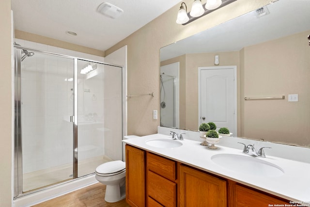 bathroom featuring vanity, toilet, and an enclosed shower