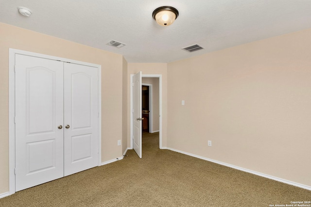 unfurnished bedroom featuring carpet flooring, a closet, and a textured ceiling