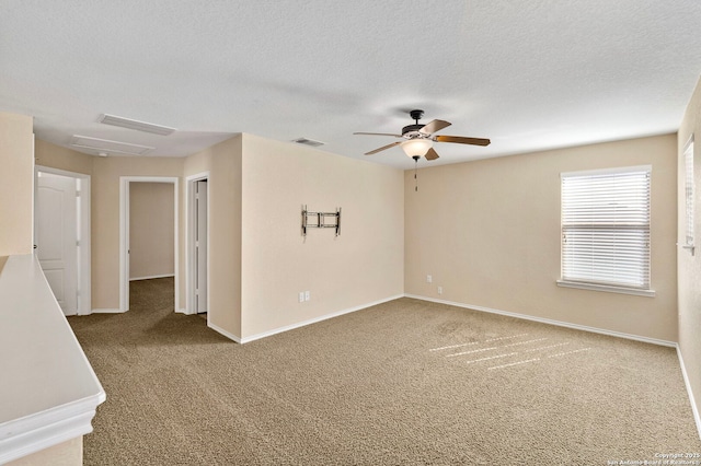 carpeted empty room with ceiling fan and a textured ceiling