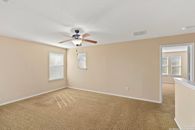 unfurnished room with a healthy amount of sunlight, carpet floors, and a textured ceiling