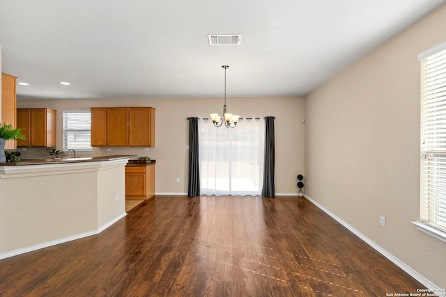 kitchen with dark hardwood / wood-style floors, decorative light fixtures, a chandelier, and sink