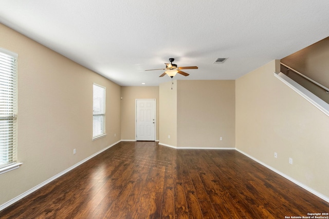 spare room with dark wood-type flooring and ceiling fan